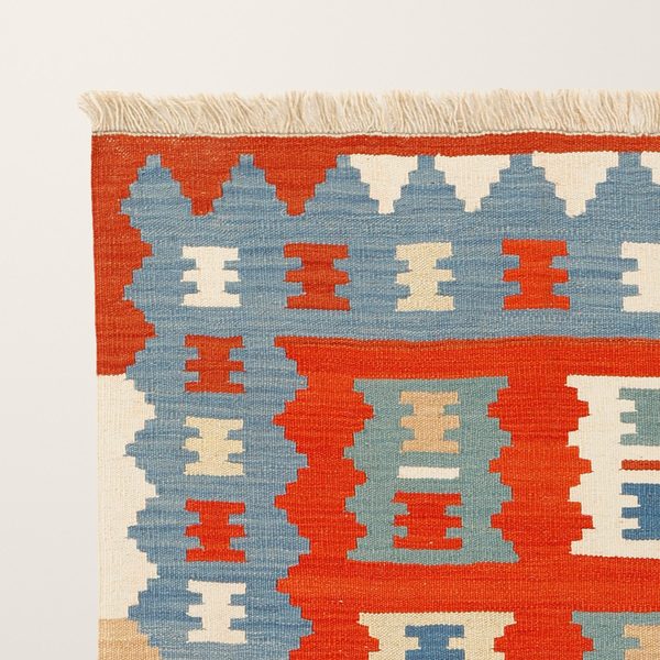 Ecke mit Fransen und blauer Bordüre mit Kammmotiv