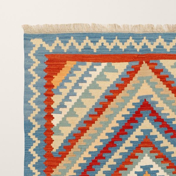 Ecke mit Fransen: blaue Bordüre und rotes Band