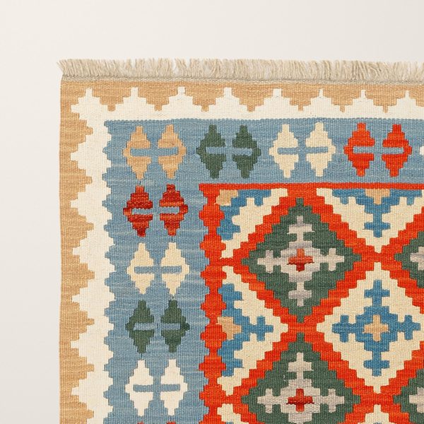Ecke mit Fransen, blauer Bordüre und hellbrauner Kante