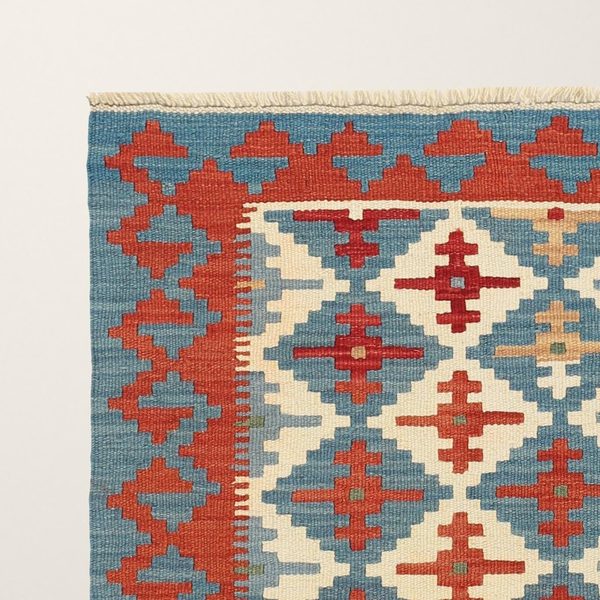 Ecke mit Fransen, roten Motiven und blauer Bordüre