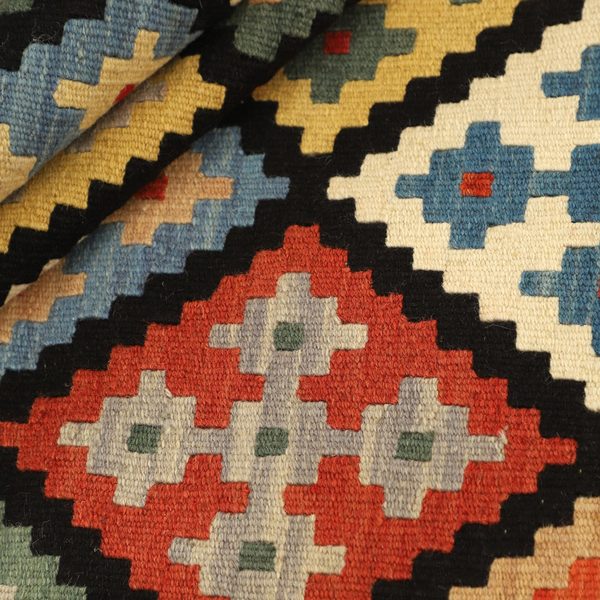 Gefalteter Kelim im Detail, rote und schwarze Rauten