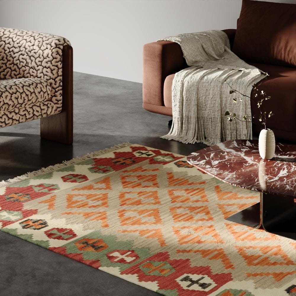 Kelim Teppich mit orangefarbenen Rauten unter einem Couchtisch in einem Wohnzimmer mit dunklem Sofa